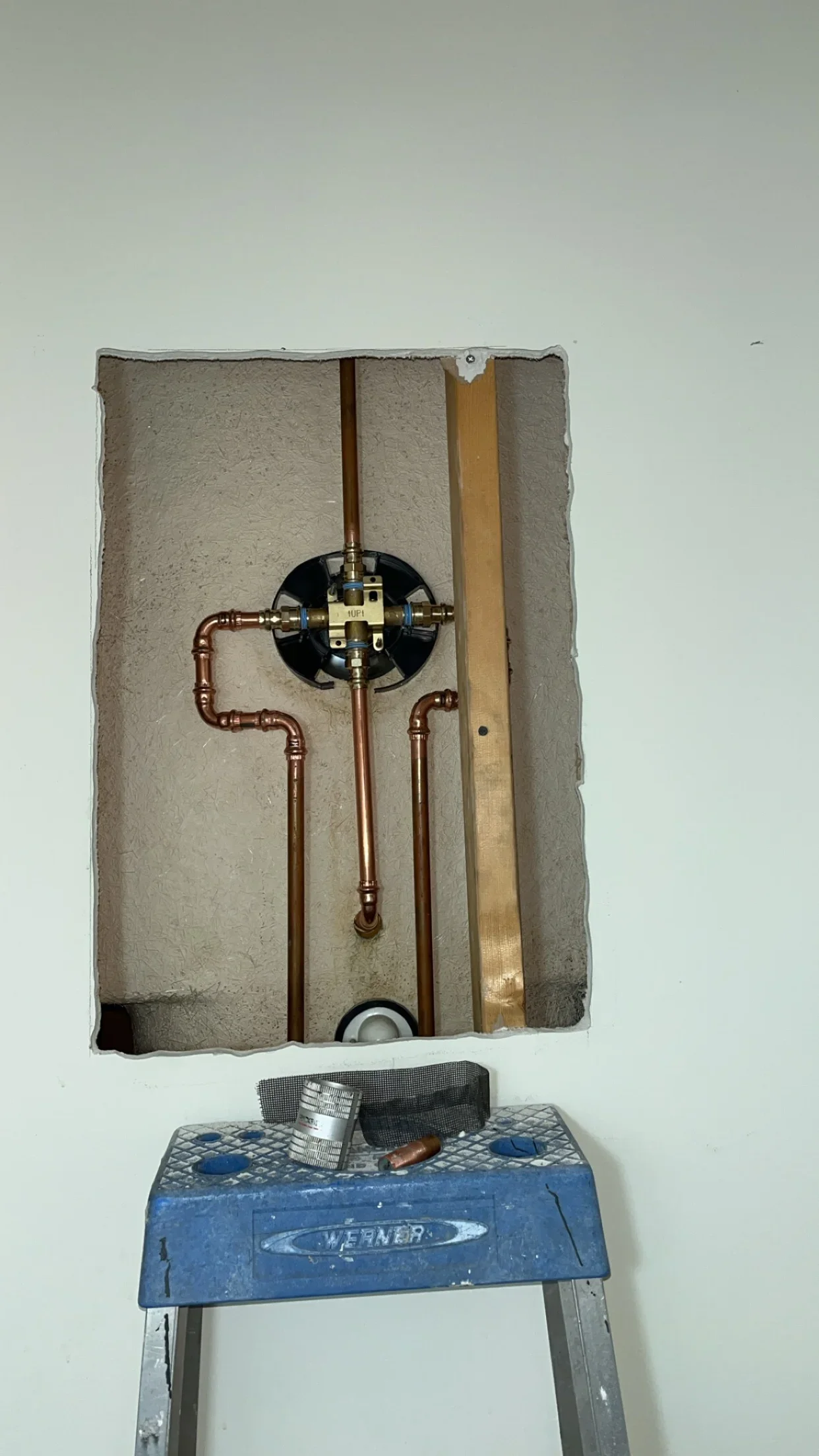 Copper water supply lines and brass valve installed in drywall cavity with proper framing