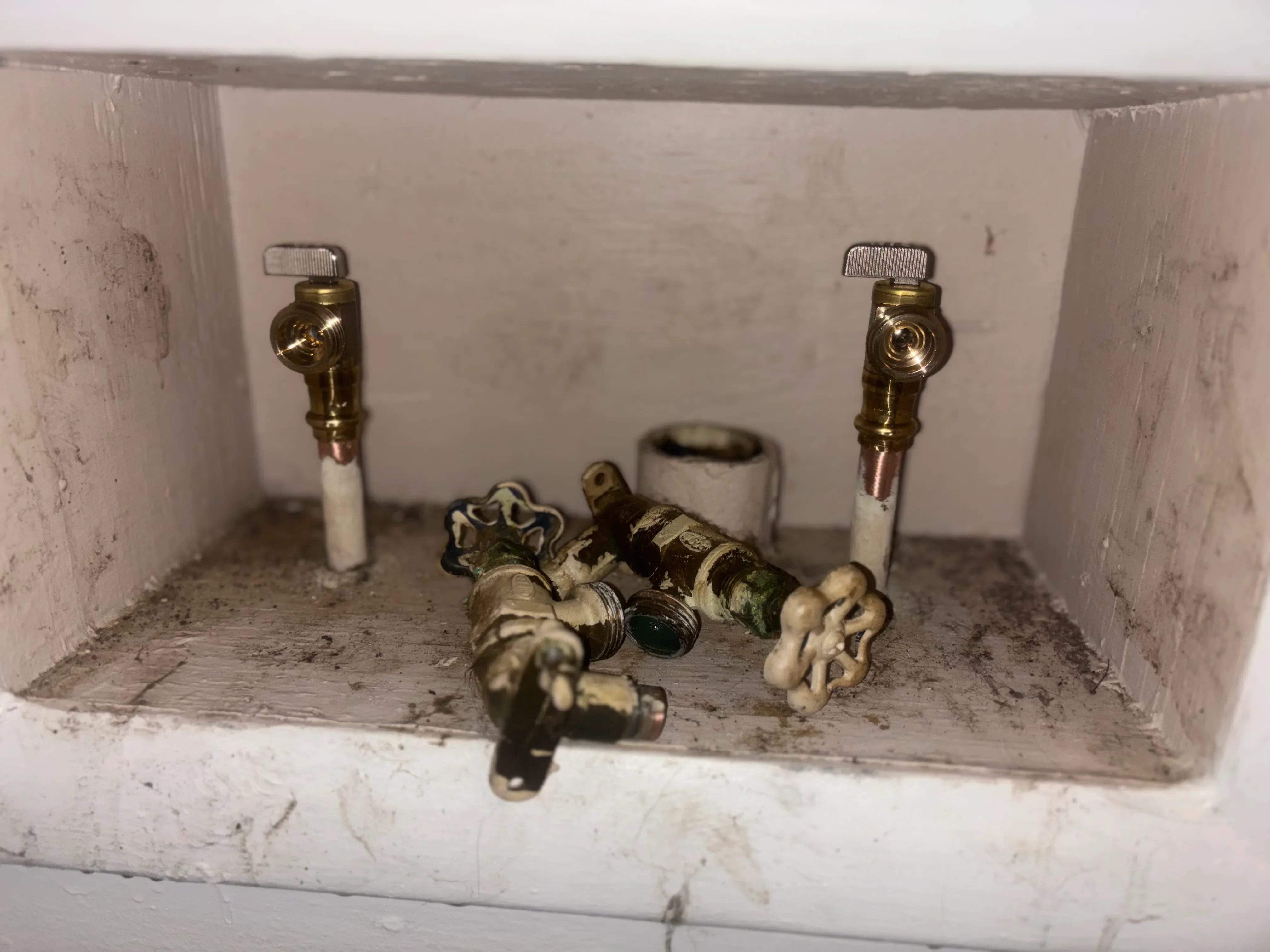 Brass shut-off valves and PVC supply lines installed under sink cabinet