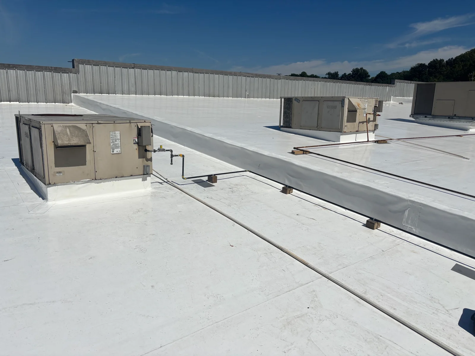 Commercial rooftop gas line installation with steel piping and HVAC equipment connections