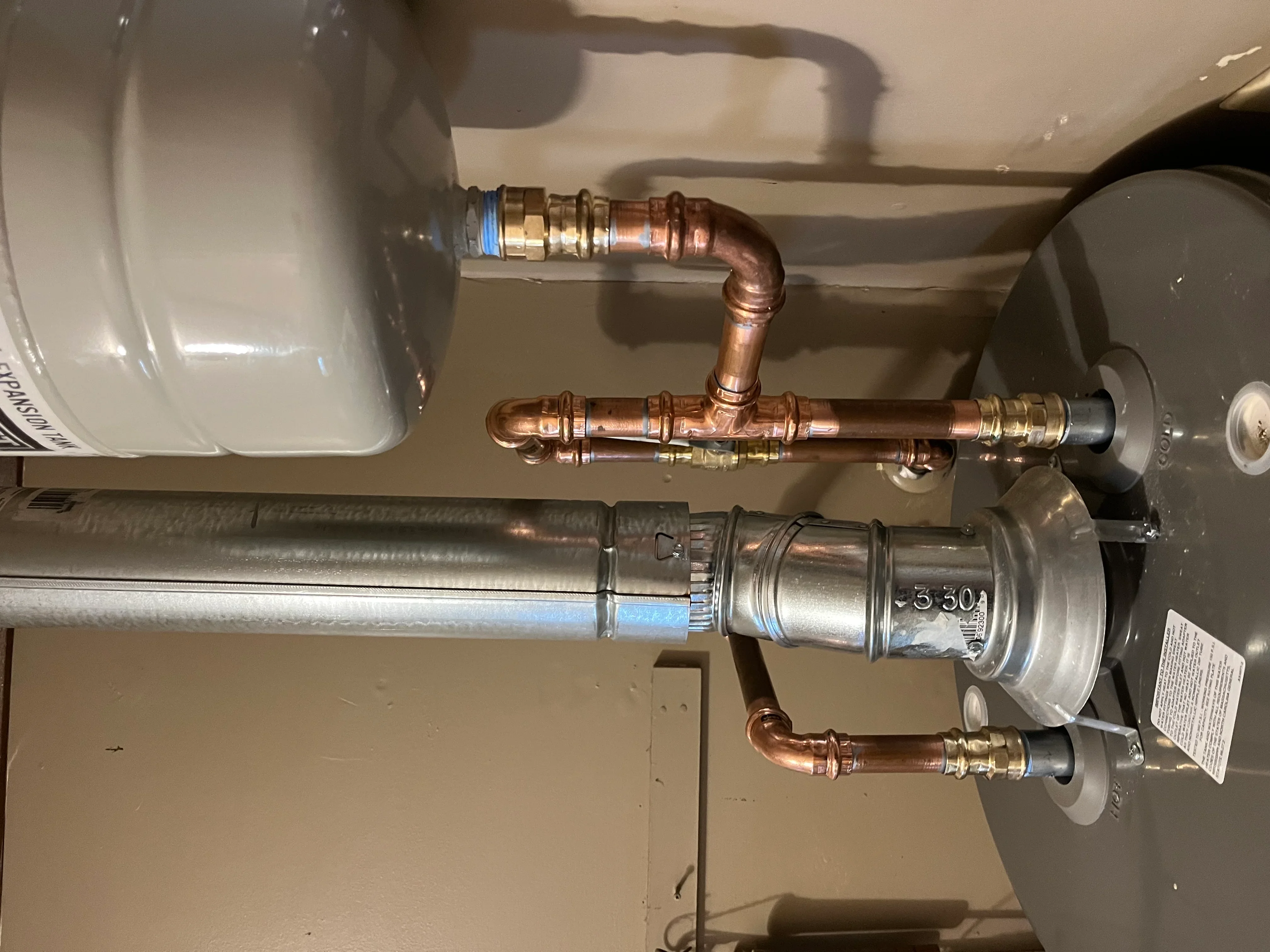 Copper piping and brass fittings connected to installed water heater with shutoff valves