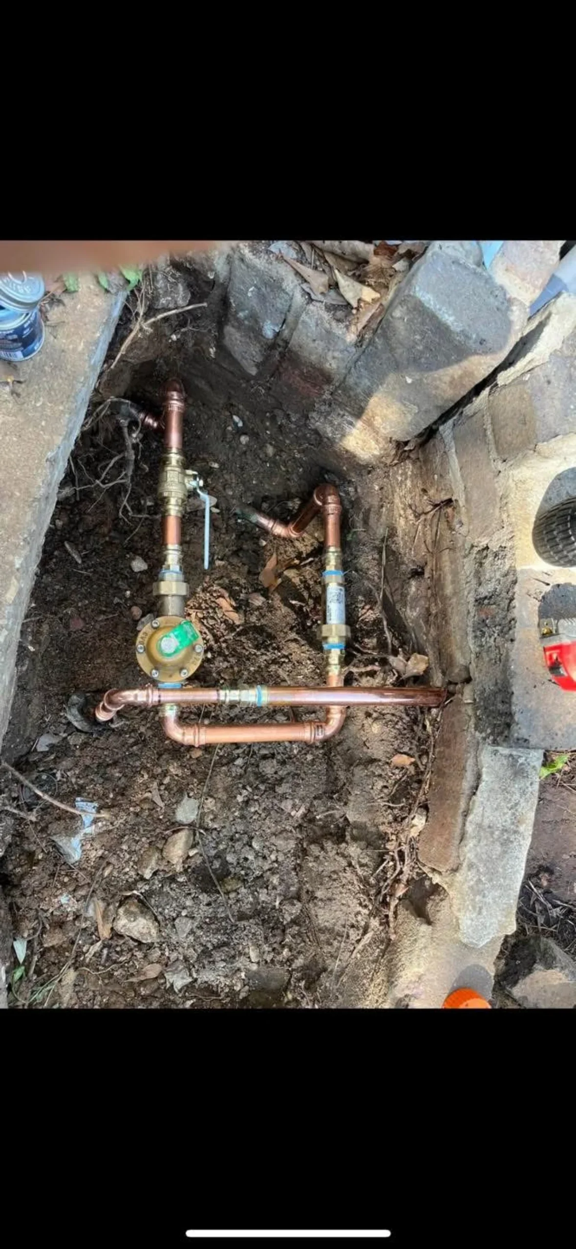 Copper water meter assembly with shut-off valves and supply lines installed in underground pit